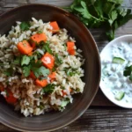 Ethnic brown rice with vegetables topped with cilantro and served with raita.