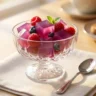 Colorful assortment of sugar-free gelatin cubes (red, orange, yellow) in a glass bowl, fresh fruit garnish, bright natural light, clean white kitchen background