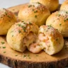 Crabby shrimp stuffed garlic bread bombs with golden crust and creamy seafood filling